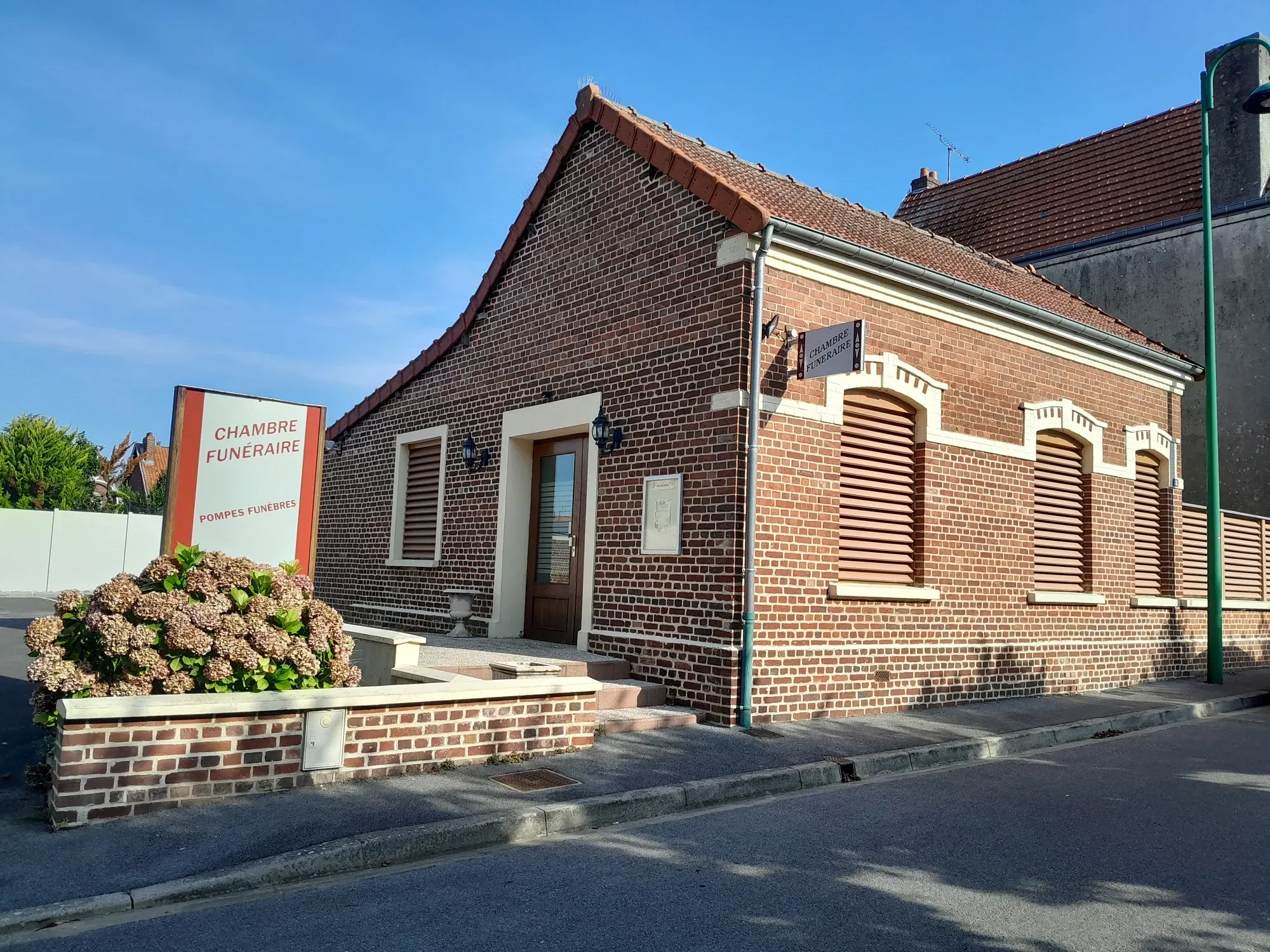 Bâtiment de chambre funéraire et pompes funèbres en briques rouges.